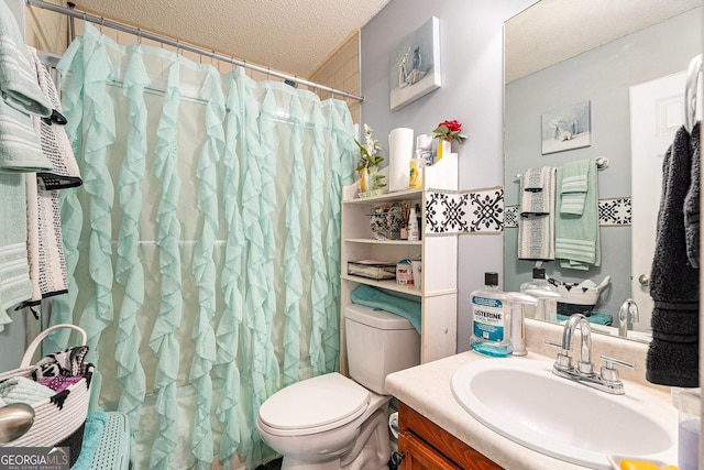 bathroom with vanity, toilet, and a textured ceiling