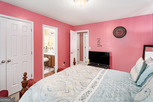 bedroom with a textured ceiling and ensuite bathroom