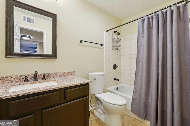 full bathroom with vanity, shower / tub combo with curtain, a textured ceiling, and toilet