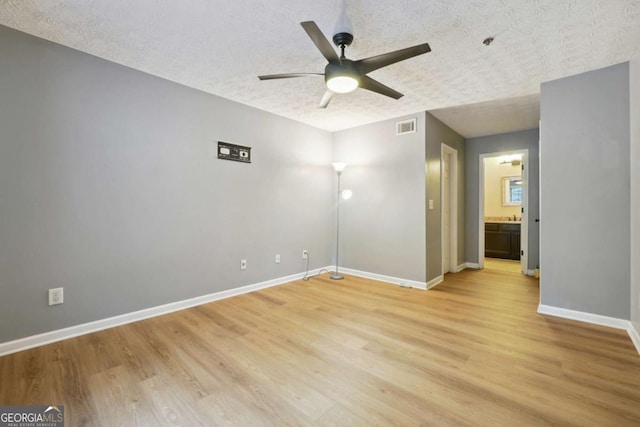 empty room with ceiling fan, a textured ceiling, and light hardwood / wood-style floors