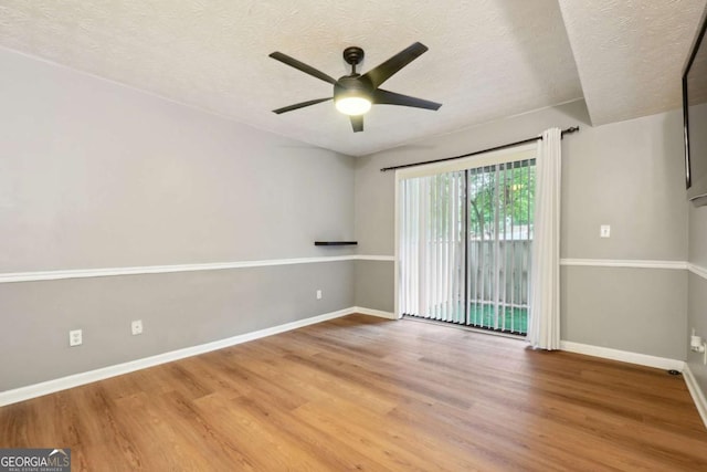 spare room featuring wood-type flooring, ceiling fan, and a textured ceiling