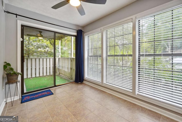 unfurnished sunroom featuring a wealth of natural light and ceiling fan