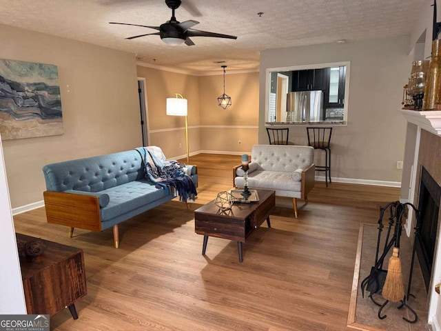 living room with hardwood / wood-style floors, a textured ceiling, and ceiling fan