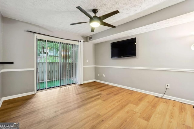 interior space with ceiling fan, wood-type flooring, and a textured ceiling