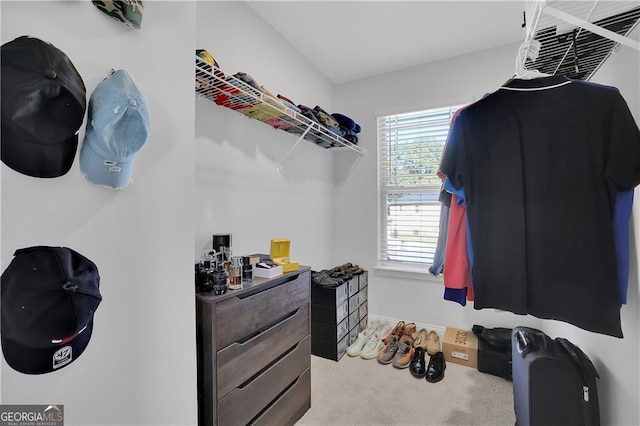 walk in closet featuring light carpet