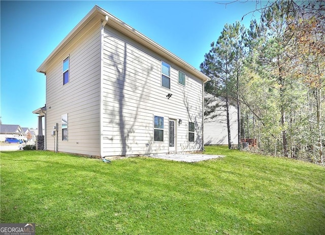 rear view of house with a yard and a patio