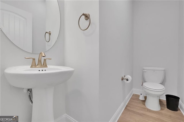 bathroom with hardwood / wood-style floors and toilet