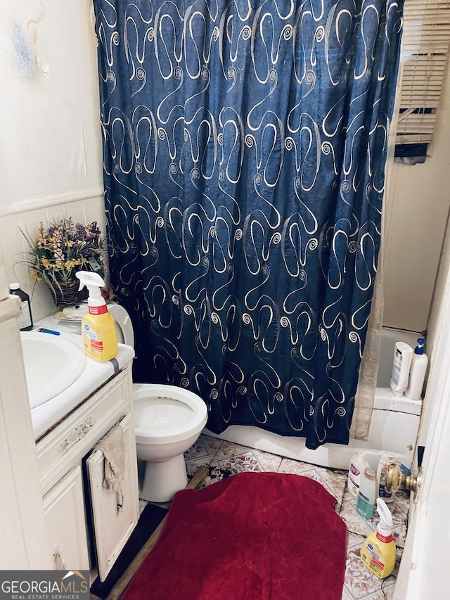 full bathroom with shower / tub combo with curtain, vanity, and toilet