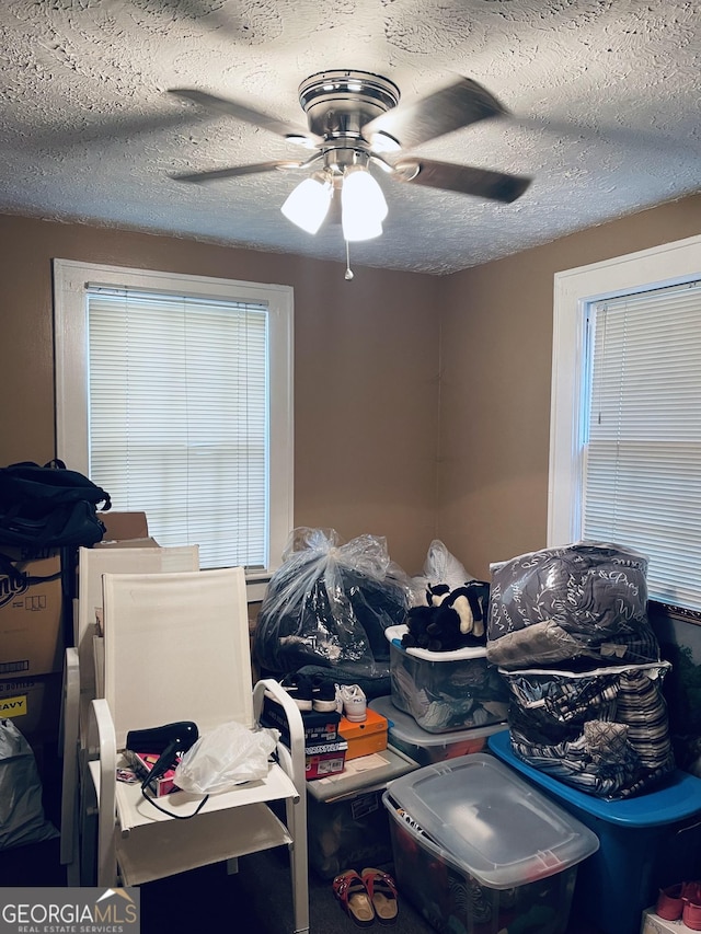 bedroom with ceiling fan and a textured ceiling