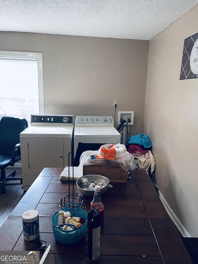 laundry room with dark hardwood / wood-style flooring, washer and dryer, and a textured ceiling