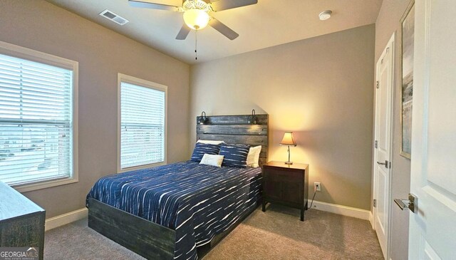 bedroom with ceiling fan and dark carpet