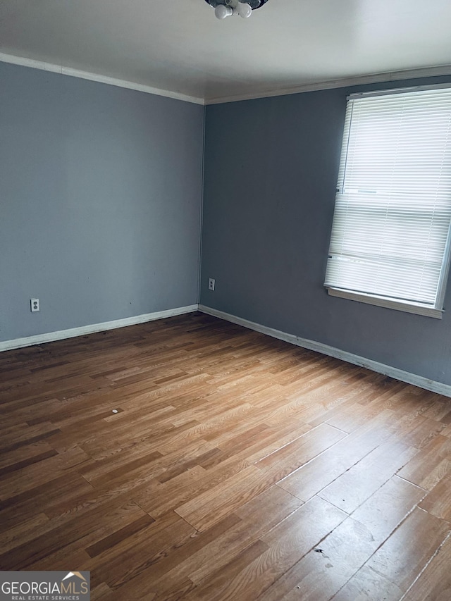 unfurnished room with crown molding and wood-type flooring