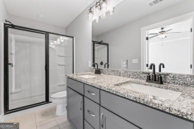 bathroom with a shower with door, ceiling fan, vanity, tile patterned floors, and toilet