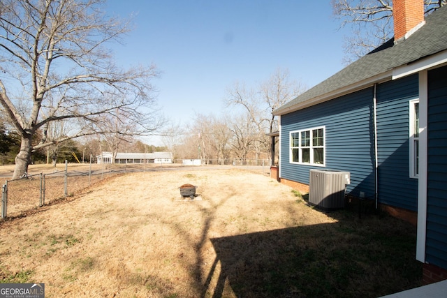 view of yard featuring central AC and an outdoor fire pit