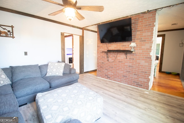 living room featuring crown molding, ceiling fan, and light wood-type flooring