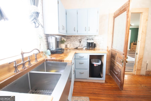 kitchen featuring sink, dark wood-type flooring, backsplash, and butcher block countertops