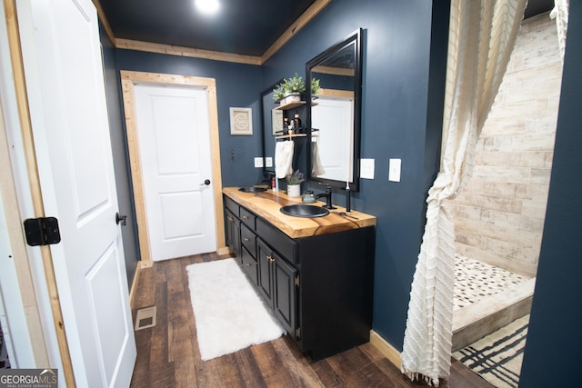 bathroom featuring vanity, crown molding, and wood-type flooring