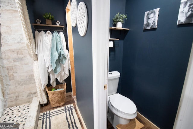 bathroom with hardwood / wood-style floors and toilet