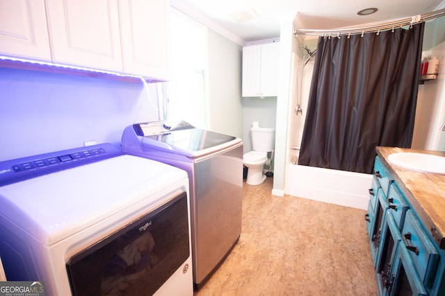 clothes washing area featuring ornamental molding, separate washer and dryer, and sink