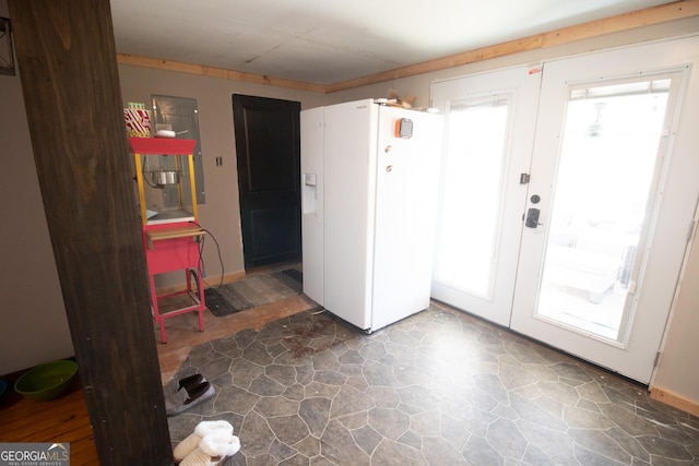 interior space with white fridge with ice dispenser and french doors