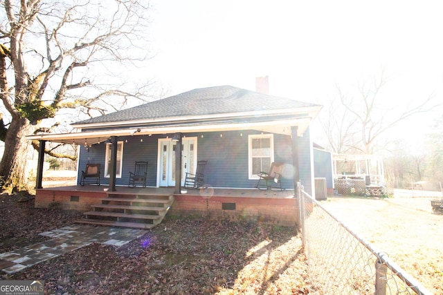 bungalow with cooling unit and a porch