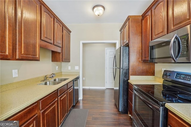 kitchen with appliances with stainless steel finishes, sink, and dark wood-type flooring