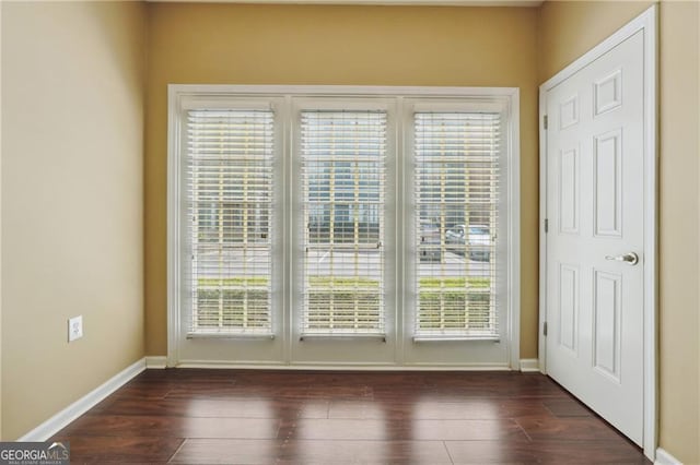 doorway to outside featuring a healthy amount of sunlight and dark hardwood / wood-style flooring