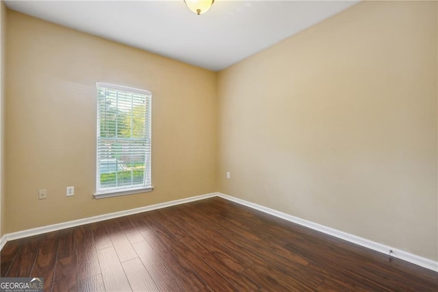 unfurnished room with dark wood-type flooring