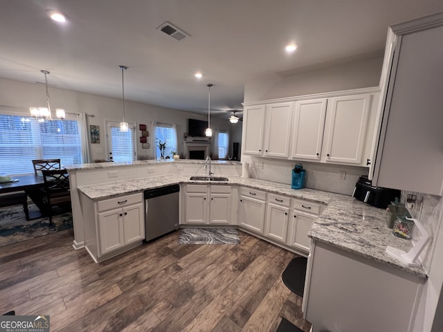 kitchen with sink, decorative light fixtures, stainless steel dishwasher, kitchen peninsula, and white cabinets