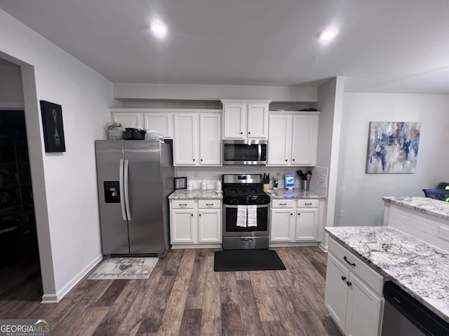 kitchen featuring light stone counters, dark wood-type flooring, stainless steel appliances, and white cabinets