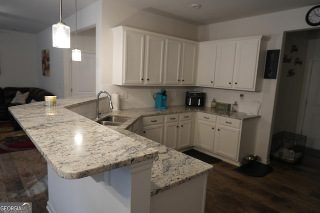 kitchen featuring pendant lighting, white cabinetry, a breakfast bar, and sink