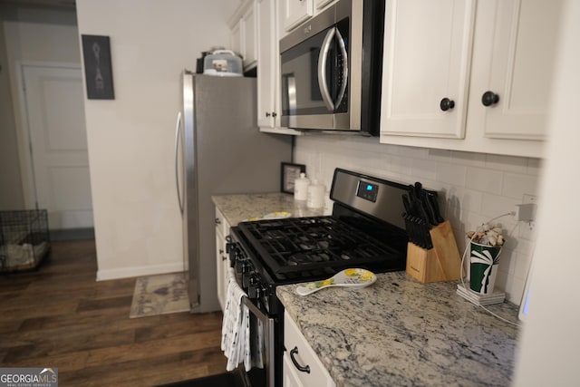 kitchen featuring white cabinetry, stainless steel appliances, and light stone countertops