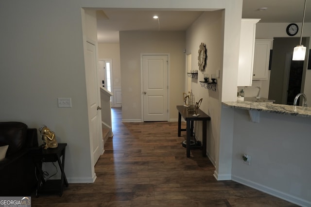 hallway with dark wood-type flooring and sink