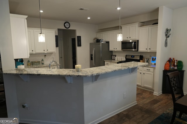 kitchen featuring hanging light fixtures, white cabinetry, appliances with stainless steel finishes, and kitchen peninsula