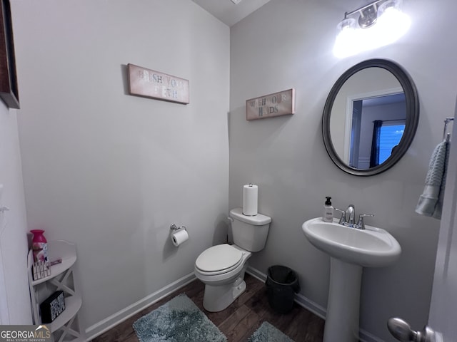 bathroom featuring sink, wood-type flooring, and toilet