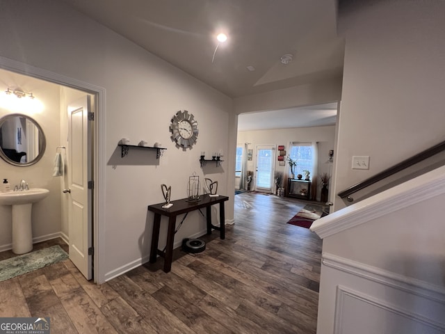 hall with lofted ceiling, dark hardwood / wood-style flooring, and sink