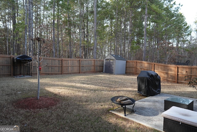 view of yard featuring a shed, a patio area, and an outdoor fire pit