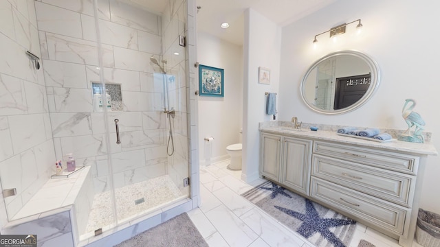 bathroom featuring vanity, toilet, and a shower with shower door