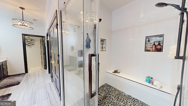 bathroom featuring vanity, an inviting chandelier, and a shower with shower door