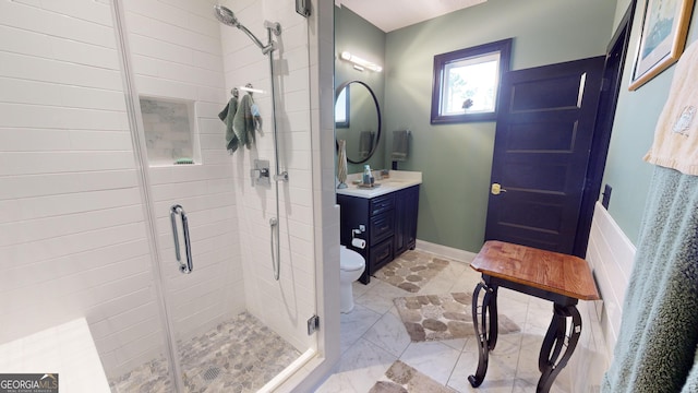 bathroom featuring vanity, a shower with door, and toilet