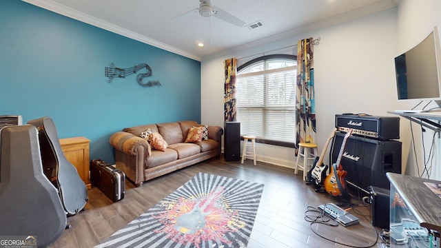 living room featuring hardwood / wood-style flooring, ornamental molding, a textured ceiling, and ceiling fan