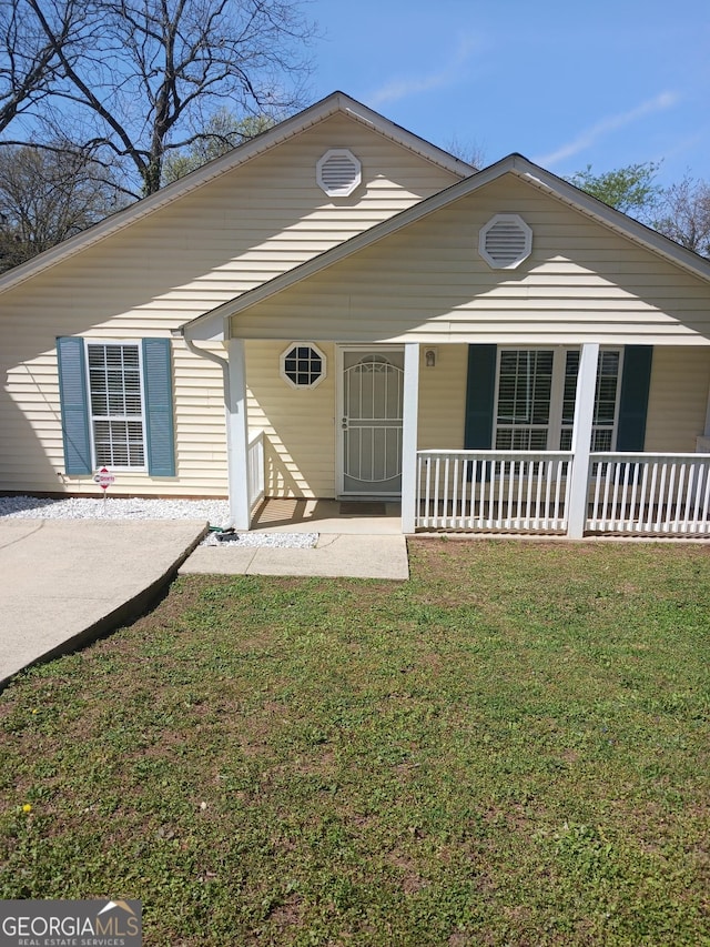 view of front of home with a porch and a front lawn