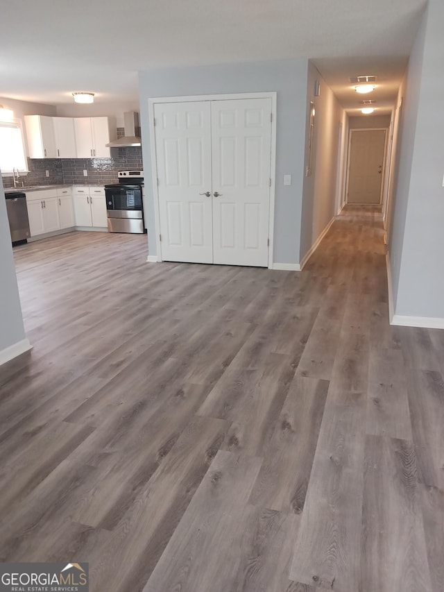 unfurnished living room with sink and hardwood / wood-style floors