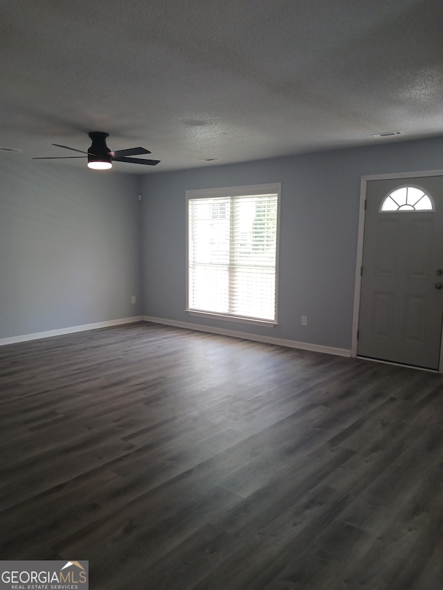 foyer with ceiling fan, dark hardwood / wood-style flooring, and a textured ceiling