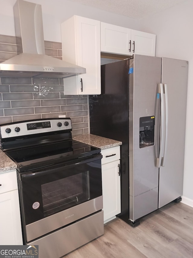 kitchen with range hood, white cabinets, and appliances with stainless steel finishes