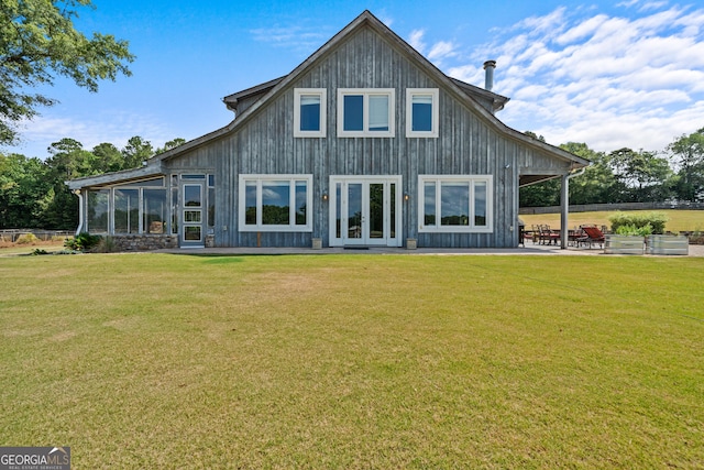 rear view of property with french doors, a patio area, and a lawn