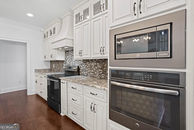 kitchen with premium range hood, ornamental molding, backsplash, white cabinetry, and stainless steel appliances