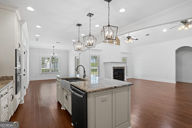 kitchen with a sink, dishwasher, a fireplace, and ceiling fan with notable chandelier