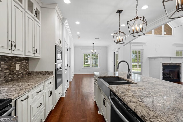 kitchen featuring crown molding, dark wood finished floors, decorative backsplash, stainless steel appliances, and a sink