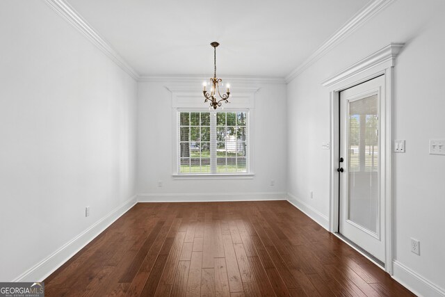 unfurnished dining area featuring baseboards, an inviting chandelier, dark wood-style floors, and ornamental molding